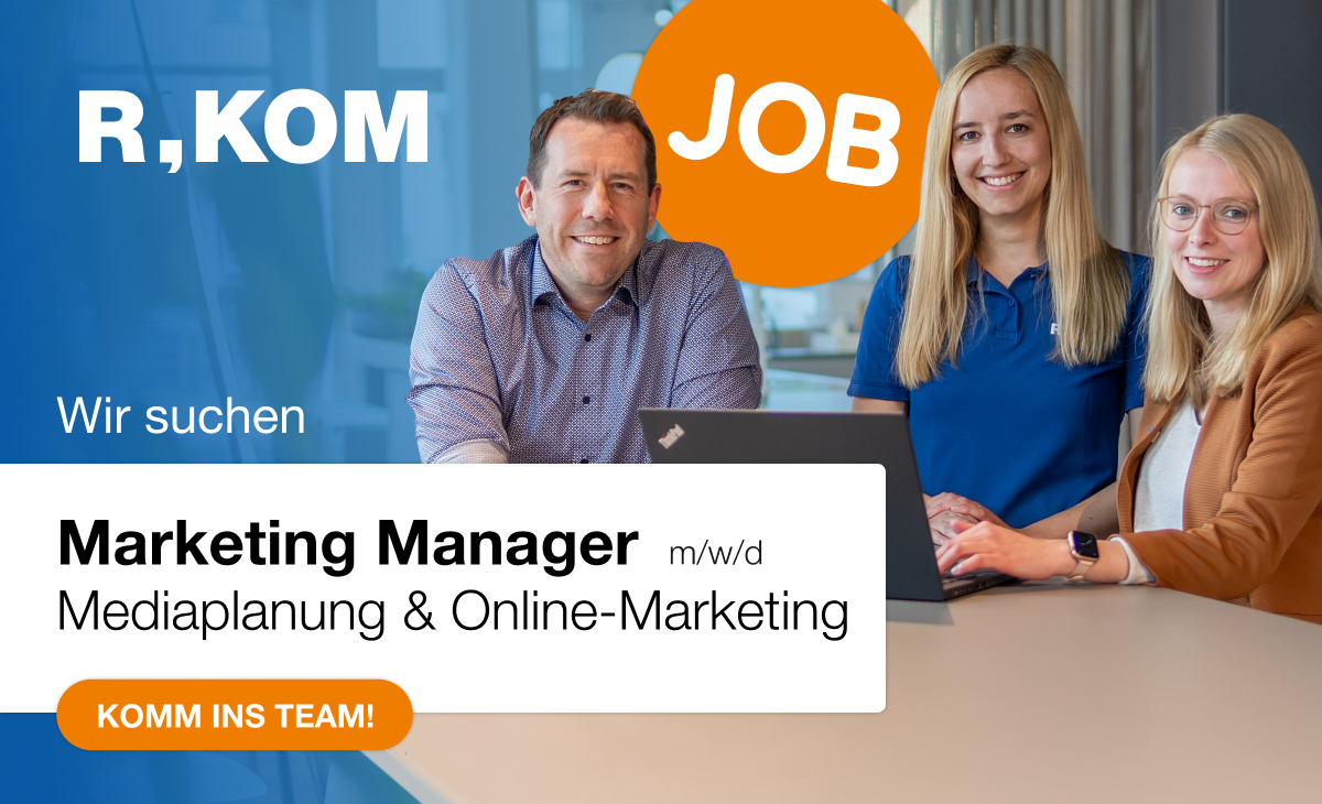 Stellenanzeige von R-KOM mit dem Text 'Wir suchen Marketing Manager (m/w/d) Mediaplanung & Online-Marketing', einem Teamfoto von drei Personen am Tisch und einem Laptop. Im oberen Bereich ist ein orangefarbener Kreis mit der Aufschrift 'JOB' zu sehen. Unten rechts ein Button mit der Aufschrift 