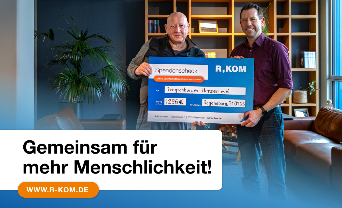 Zwei Männer halten einen Spendenscheck von R-KOM über 1.296 € für den Verein 